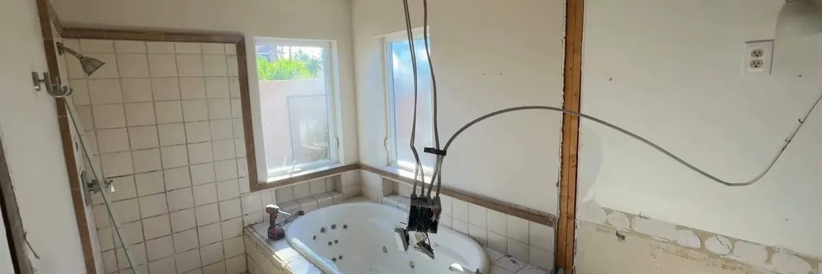 Wide view of open bathroom wall with new plumbing rough-in for Bathroom Plumbing Remodel service in Mechanicsburg