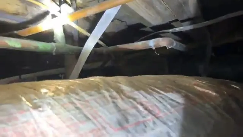 Close view of crawlspace drain pipe repair below a home for plumbing service in Grantham