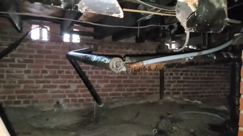 Close view of crawlspace drain pipe repair below a home for plumbing service in Lower Allen Township