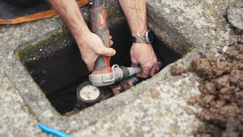 Close view of open sewer lateral repair with pipe exposed in the ground for Root Intrusion and Your Sewer Line