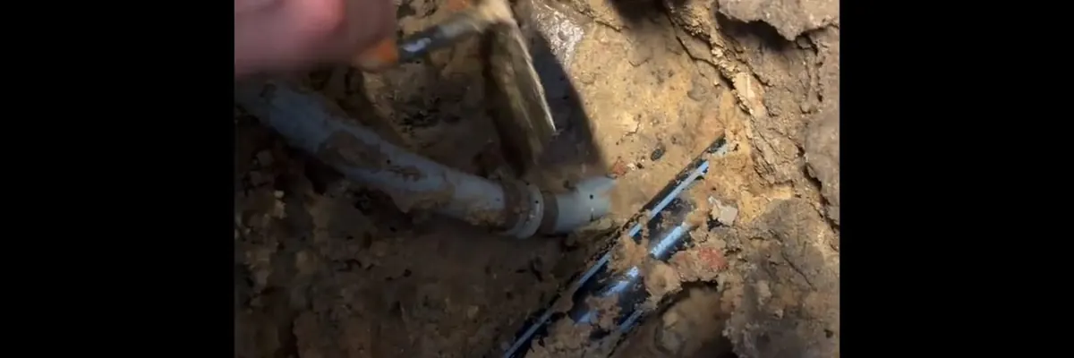 Wide view of open sewer lateral repair with pipe exposed in the ground for Sewer Line Repair service in Mechanicsburg