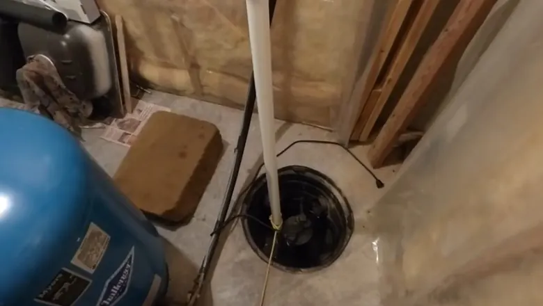 Close view of sump pump basin and discharge piping in a basement for Preparing Your Sump Pump for Spring: West Shore PA
